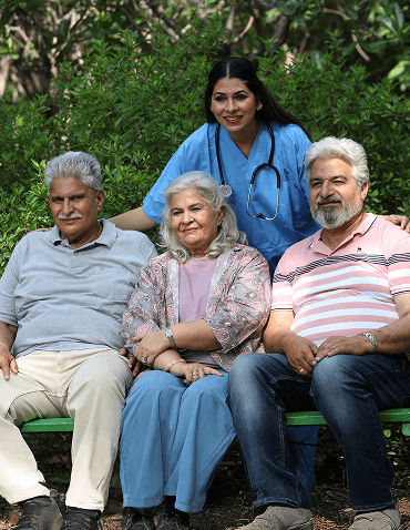 Elders with caregiver in park.