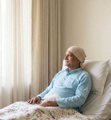 Old man resting on bed and having treatment going on