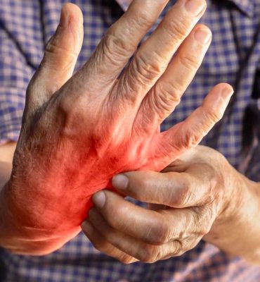Senior massaging their hand to relieve arthritis joint pain and stiffness.