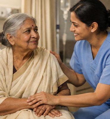 A compassionate nurse in blue scrubs smiles warmly while comforting an elderly woman sitting on a hospital bed, holding her hands to provide dedicated hospitalization support for a senior patient.